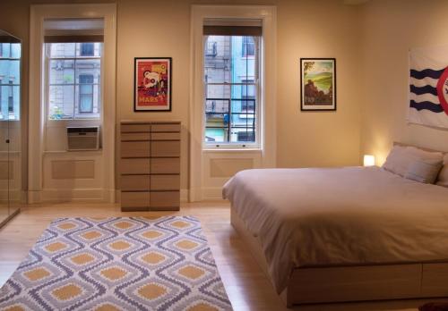 a bedroom with a bed and two windows and a rug at Center of Action PARK ONSITE Gated on 2nd Fl in Cincinnati