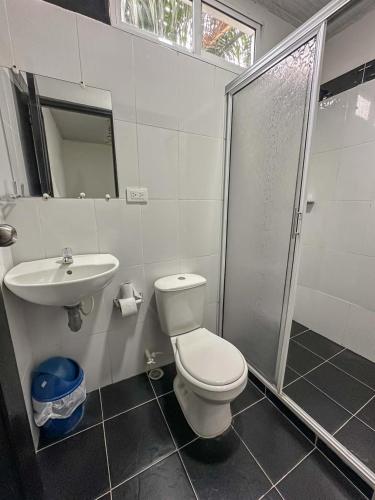 a bathroom with a toilet and a sink and a shower at HOTEL COLONIAL santorini colombiano in Doradal