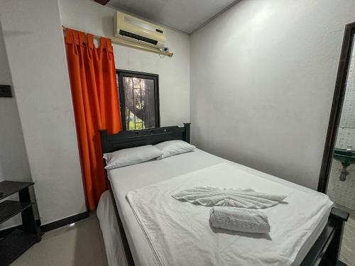 a bedroom with a bed with an orange curtain at HOTEL COLONIAL santorini colombiano in Doradal