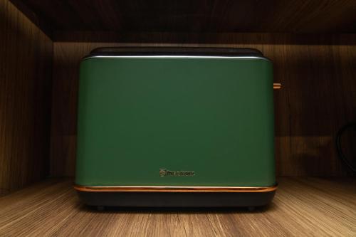 a green suitcase sitting on top of a wooden floor at Studio Confortable et Cozy - Maarif Casablanca in Casablanca