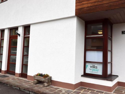 a white building with a window and a pot of flowers at Apartment Katharina in Steinach am Brenner