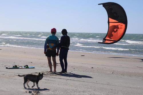 two people and a dog on the beach with a kite at Treehouse Jericoacoara in Jericoacoara