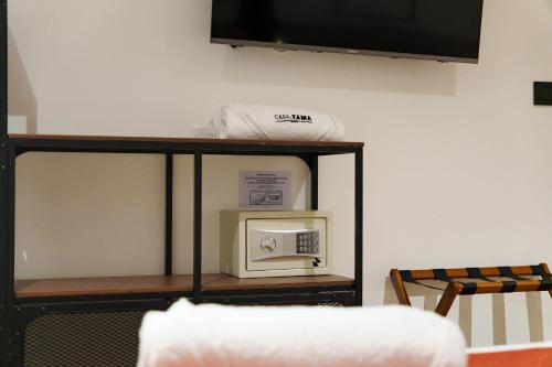a shelf with a microwave on top of it at Hotel CASA TAMA in Salento