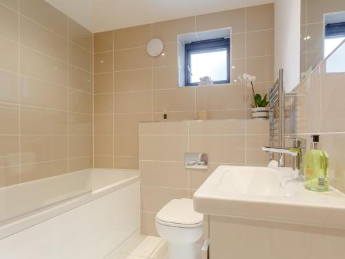 une salle de bain avec toilettes, lavabo et baignoire dans l'établissement 4 Bed in Westward Ho 72587, à Northam