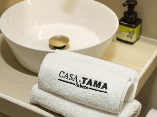 a pile of towels sitting on a counter next to a sink at Hotel CASA TAMA in Salento