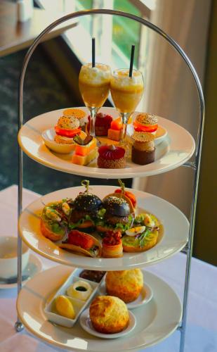 a three tiered tray with three plates of food and drinks at Waitakere Resort & Spa in Auckland