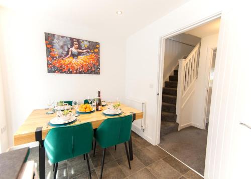 a dining room with a table and green chairs at Premium Contractors House near M6 J3 & CBS Arena in Coundon