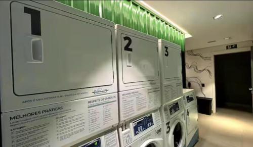 a laundry room with a washing machine on a wall at Estúdio de Luxo Essenza in São Paulo