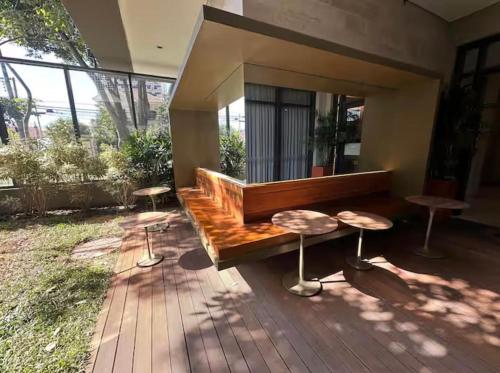 a patio with a wooden bench and two stools at Estúdio de Luxo Essenza in São Paulo