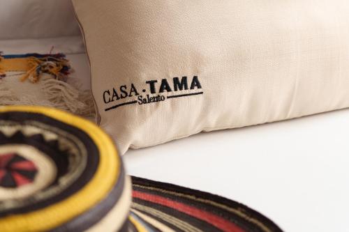 a pillow with the words casa tiana studied on it at Hotel CASA TAMA in Salento