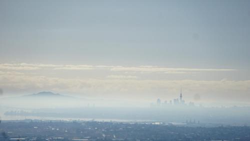 a foggy city with a city in the distance at Waitakere Resort & Spa in Auckland