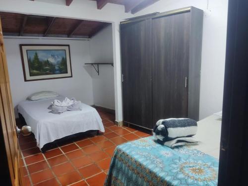 Cet appartement comprend une chambre avec un lit et une armoire. dans l'établissement El Refugio, à Guatapé