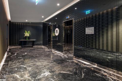 a bathroom with black tile walls and a marble floor at Top Floor Stylish 1BR Apt in Southbank View Pool Gym in Melbourne