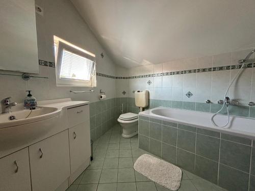 a bathroom with a tub and a toilet and a sink at Apartments by the sea Kukljica, Ugljan - 24795 in Kukljica