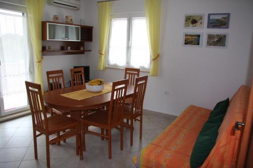 a dining room with a table and chairs and a bed at Apartment Anethum in Premantura