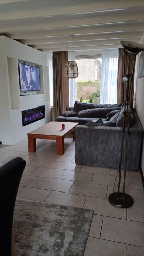 a living room with a couch and a coffee table at Family home near the city center! in Oudenbosch