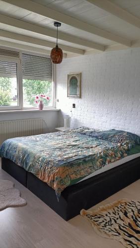 a bedroom with a large bed in a room at Family home near the city center! in Oudenbosch