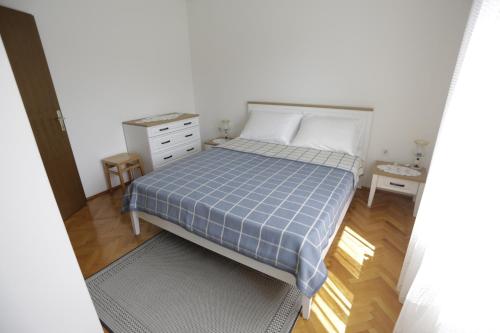 プナトにあるApartments by the sea Punat, Krk - 24811のベッドルーム1室(青いプライドの毛布付きのベッド1台付)