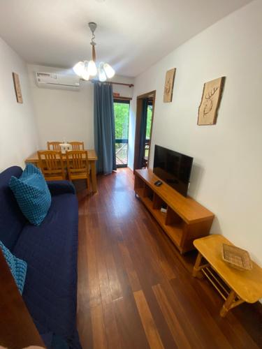 a living room with a blue couch and a tv at Gerês River - Apartamento na Natureza in Geres