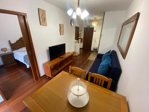 a living room with a table and a couch at Gerês River - Apartamento na Natureza in Geres