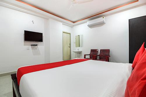 a bedroom with a white bed and a tv at Super Hotel O New Cyber Grand Madhapur in Hyderabad