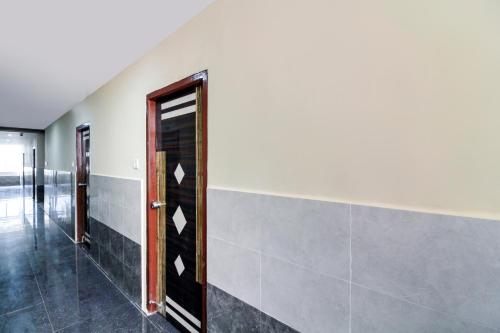 a hallway with a door and a tile wall at Super Hotel O New Cyber Grand Madhapur in Hyderabad