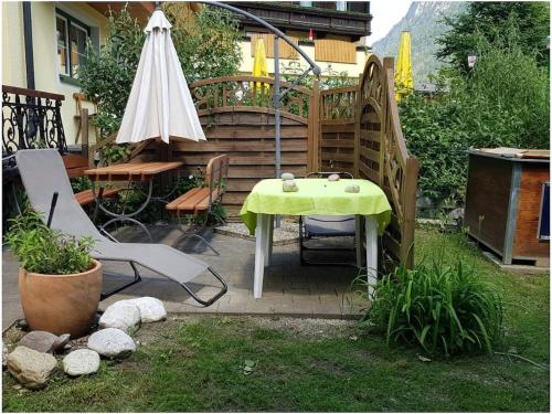 a table and chairs and an umbrella in a yard at Müller Holiday Home Salzburgerland in Unken