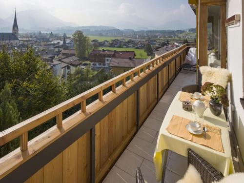 a balcony with a table and a view of a city at - Chalet Panorama View in Kössen