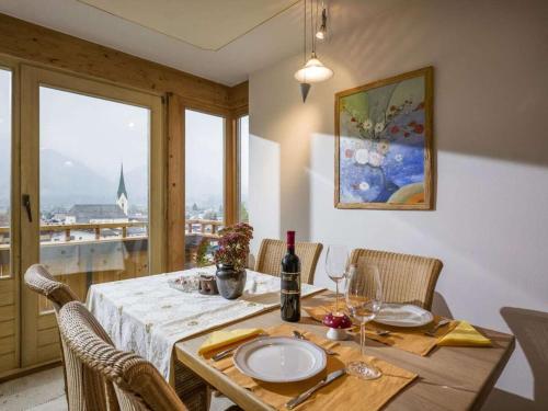 a dining room with a table and chairs with a window at - Chalet Panorama View in Kössen