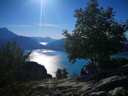 two people sitting on top of a hill overlooking a lake at One-bedroom apartment in Nussdorf am Attersee