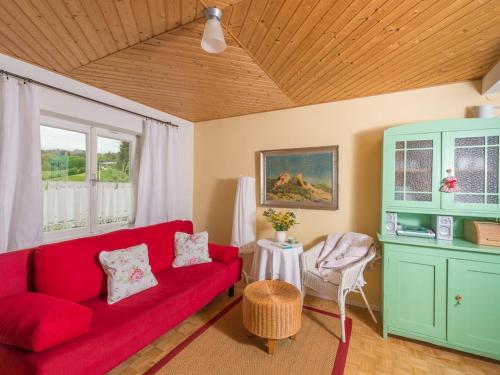 a living room with a red couch and a table at One-bedroom apartment in Nussdorf am Attersee