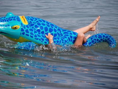 a child laying on its back in the water at One-bedroom apartment in Nussdorf am Attersee