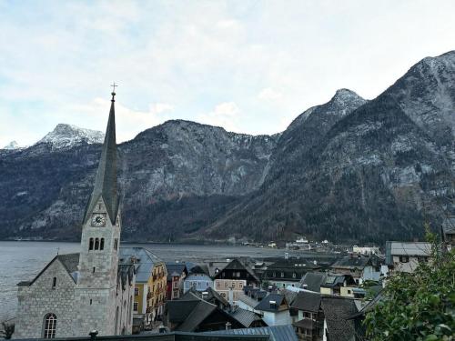 a town with a church and mountains in the background at One-bedroom apartment in Nussdorf am Attersee