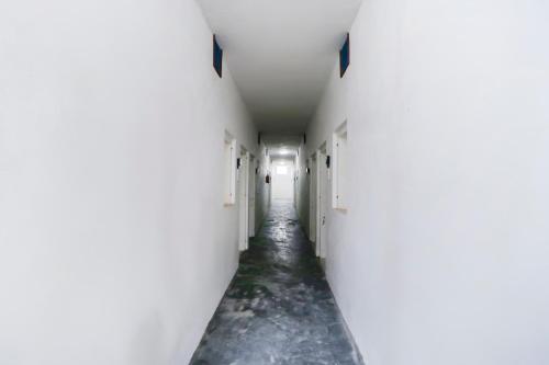 ein leerer Flur mit weißen Wänden und einem langen Gang in der Unterkunft Hotel O MCK Rooms in Rūpnagar