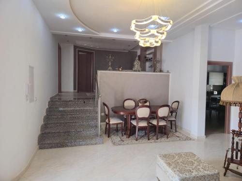 a dining room with a table and chairs and a chandelier at Villa de plage Sousse in Sousse