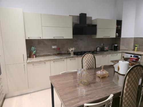 a kitchen with a wooden table and white cabinets at Villa de plage Sousse in Sousse