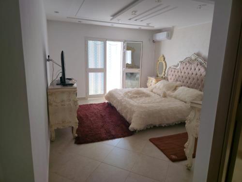 a bedroom with a bed and a mirror and a window at Villa de plage Sousse in Sousse
