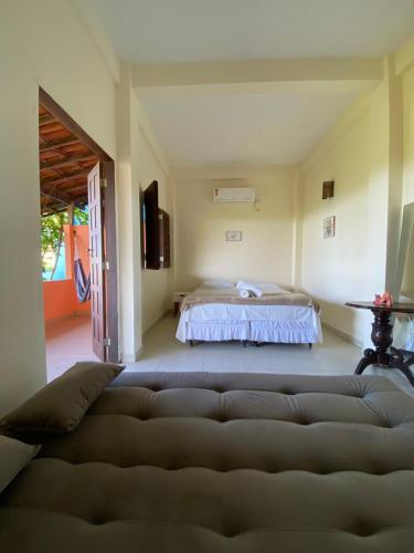 a living room with a bed and a couch at Bem Me Quer Casas in Morro de São Paulo