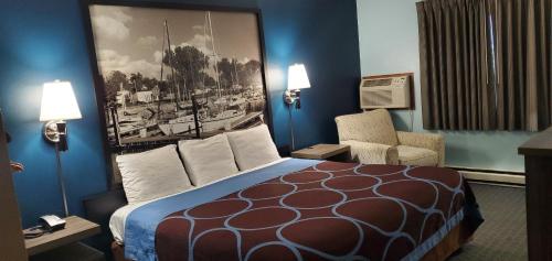 a hotel room with a bed and a chair at River Hill Inn & Suites in Hudson
