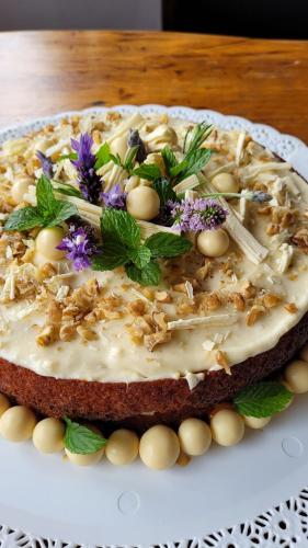 a cake with nuts and flowers on top on a plate at Hostal Boutique El Vergel Azul in Castro