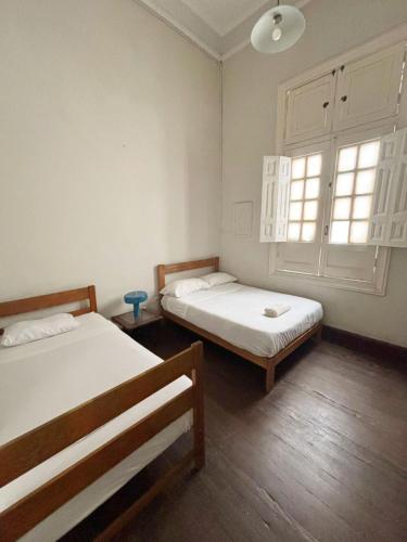 a room with two beds and a window at 1900 Backpacker's Hostel in Lima