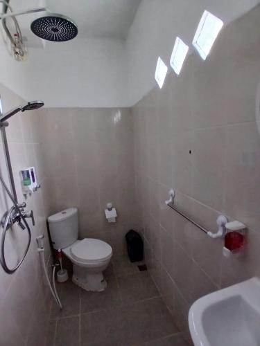 a bathroom with a toilet and a sink at Sumatra Cheeky Monkeys Villa, Trekking and Tours in Bukit Lawang