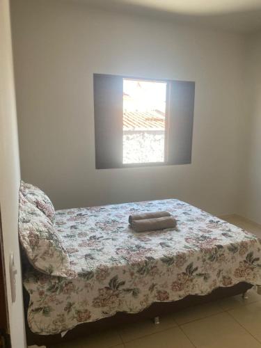 a bedroom with a bed with a blanket and a window at Casa Bela Vista II in São Roque de Minas