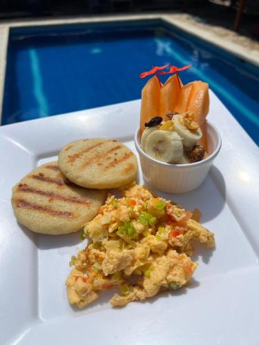 a plate of food with toast and a bowl of fruit at Rincon del Mar Palomino in Palomino