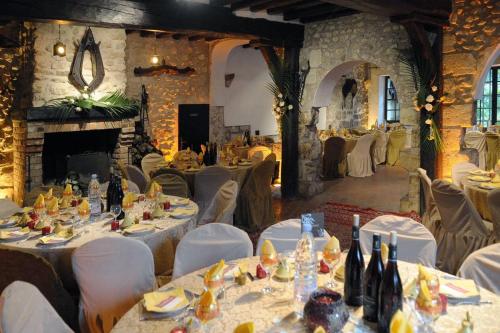 ein Esszimmer mit Tischen und Stühlen und einem Kamin in der Unterkunft Moulin de Moulignon B&B in Messy