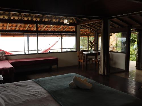 a bedroom with a bed and a table in a room at Bem Me Quer Casas in Morro de São Paulo