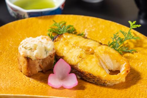 a yellow plate with a piece of food on it at Hakone Yumoto Onsen Hotel Kajikaso in Hakone