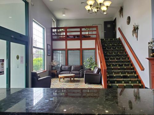 a lobby with a staircase and a living room at River Hill Inn & Suites in Hudson