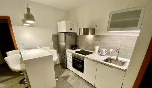 a small kitchen with a sink and a stove at Apartments by the sea Ist - 22436 in Ist