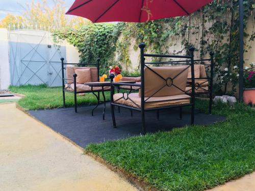 a table and chairs under an umbrella on a lawn at paradis in Aït Bou Setta